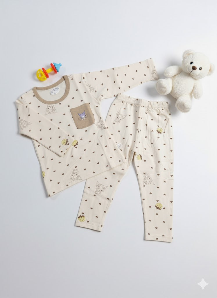 Baby outfit with long-sleeve shirt and pants on a white background, accompanied by a teddy bear and colorful toy.